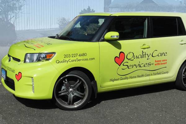 Quality care service logo printed on a yellow car